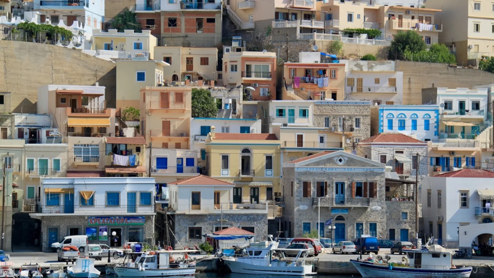 white and blue boat on dock near buildings during daytime